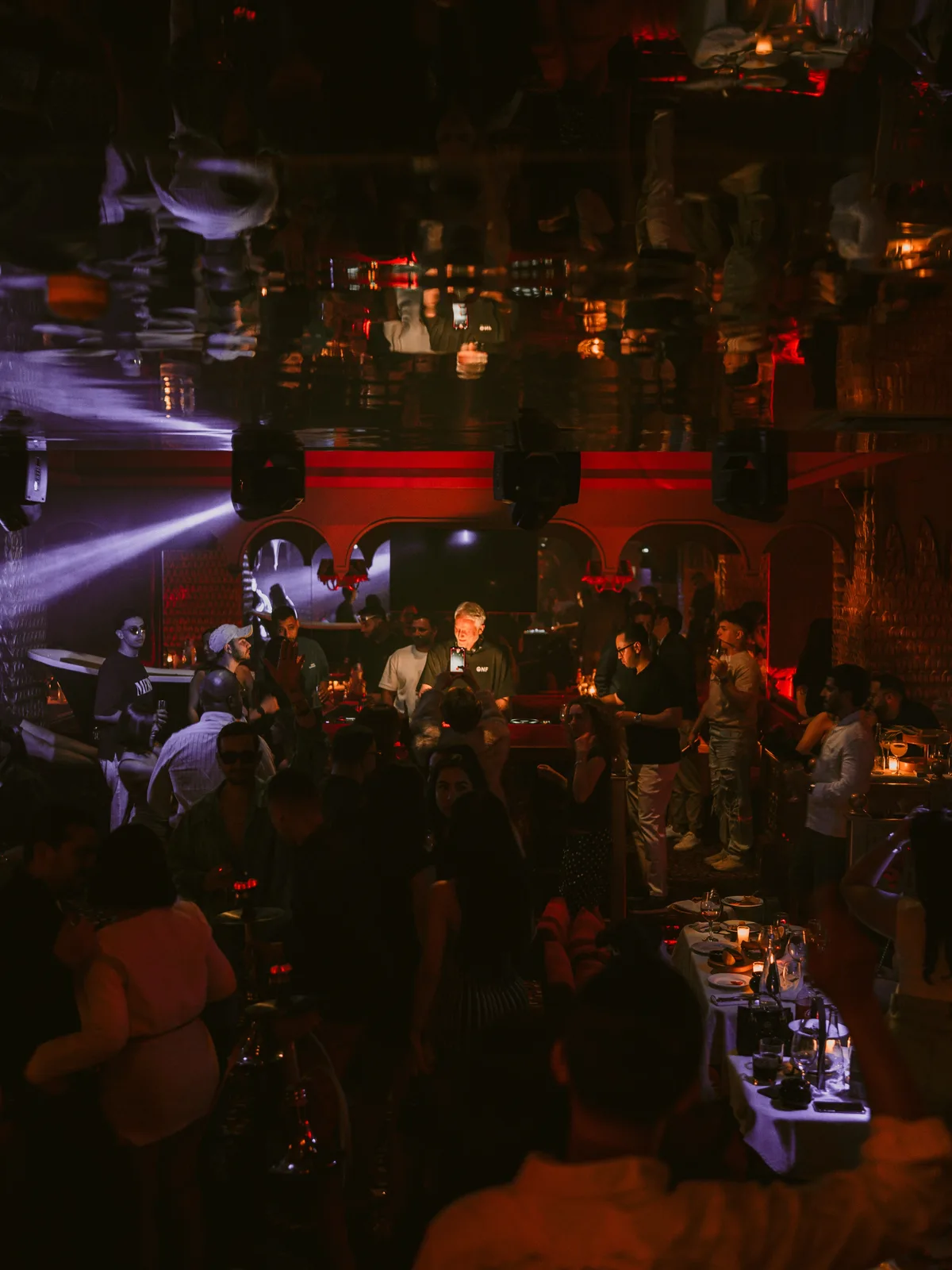 Crowd, tables and nightlife lighting inside The Club Agadir