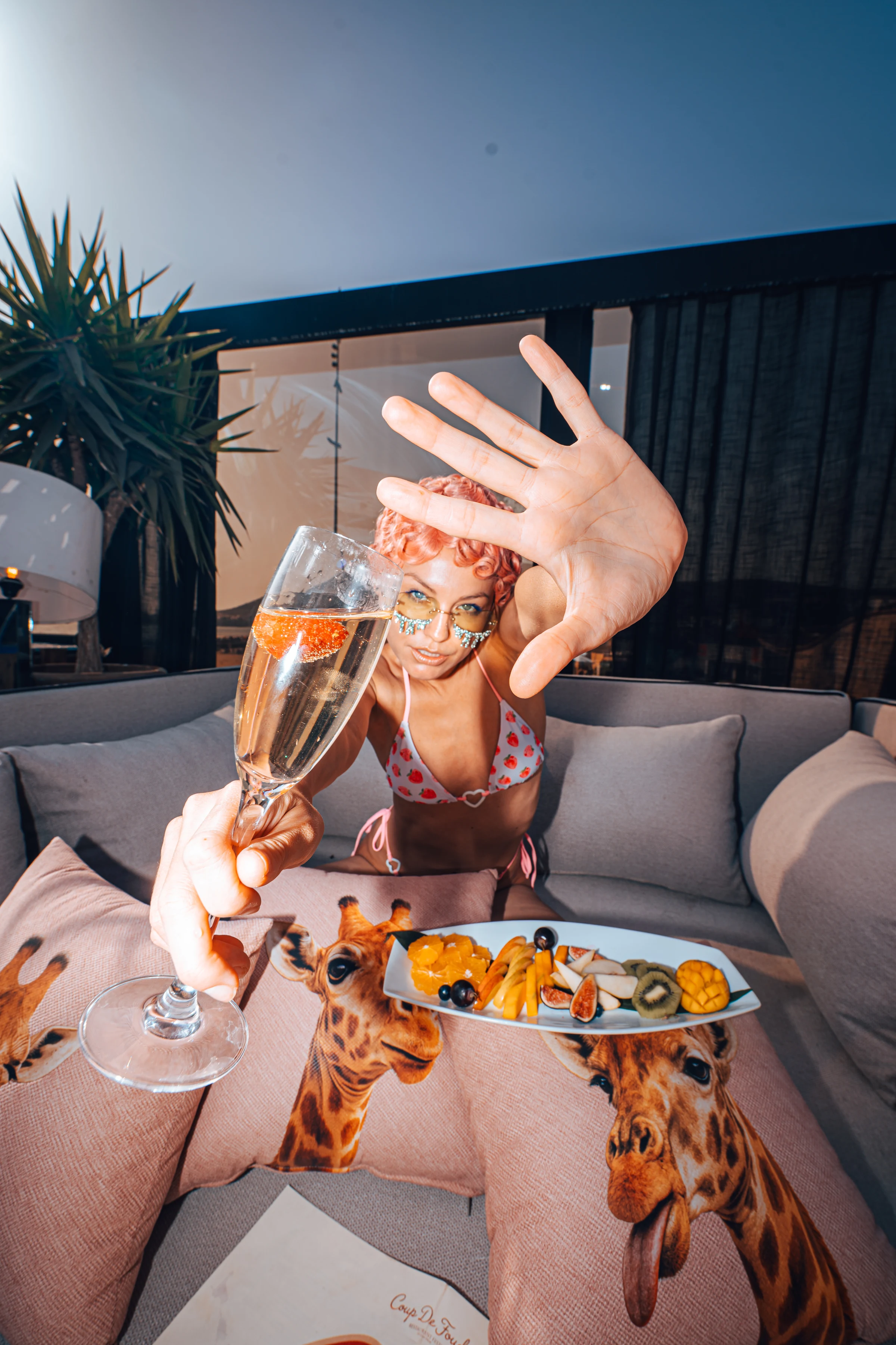 A guest raising a champagne glass at the Coup de Foudre Rooftop